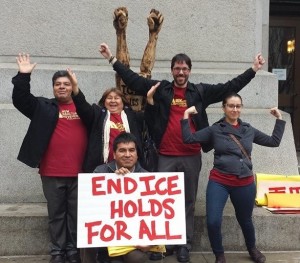 Five activists holding an "End ICE Hold For All" sign.