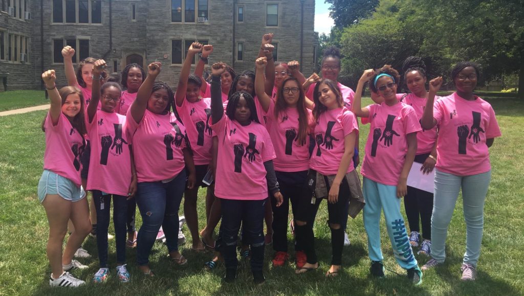 Girls and young women from Girls Justice League raise their fists